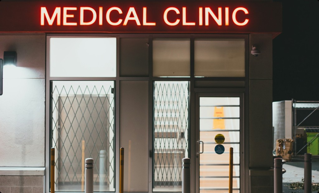 Medical clinic storefront at night with a neon sign